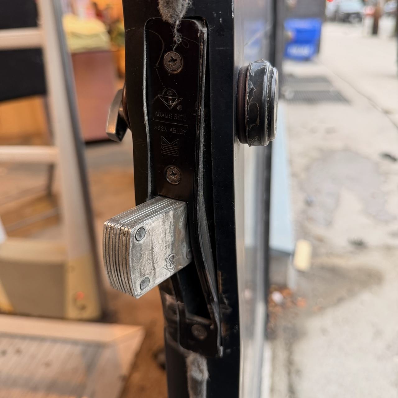 Damaged mortise lock inside an aluminum storefront door after forced entry