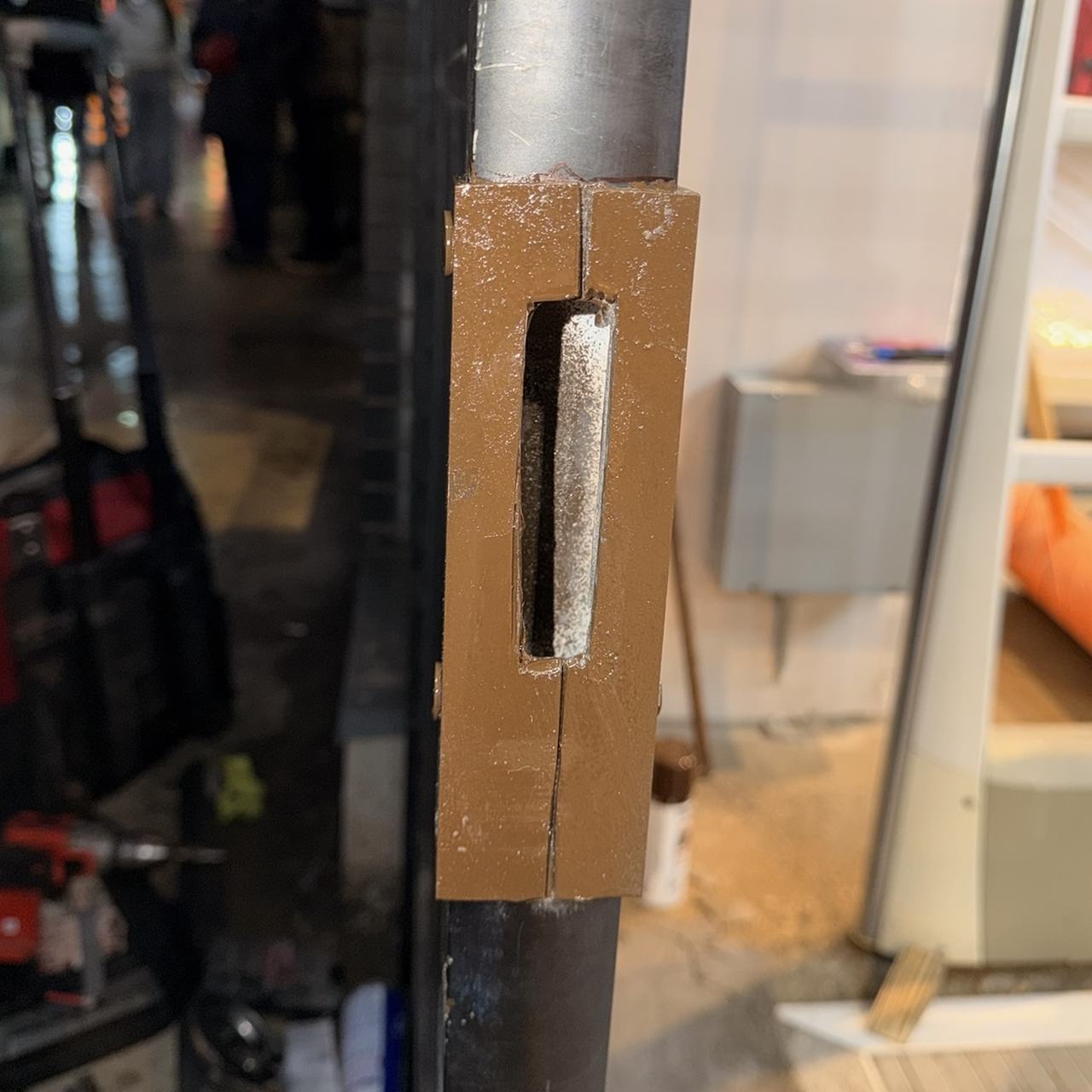 Metal reinforcement installed over a damaged commercial door strike area