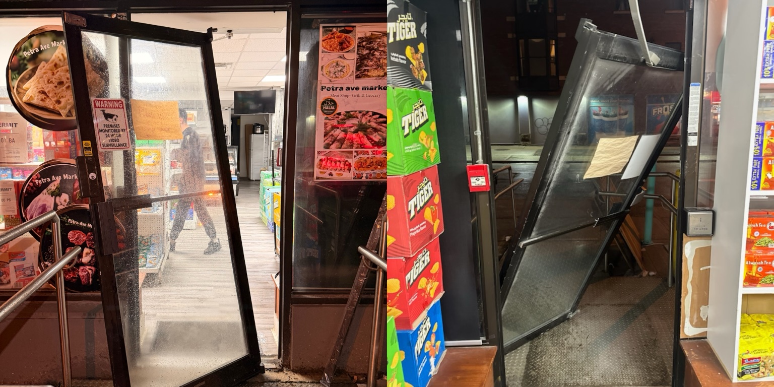 Two damaged commercial entrance doors displaced from their frames before repair