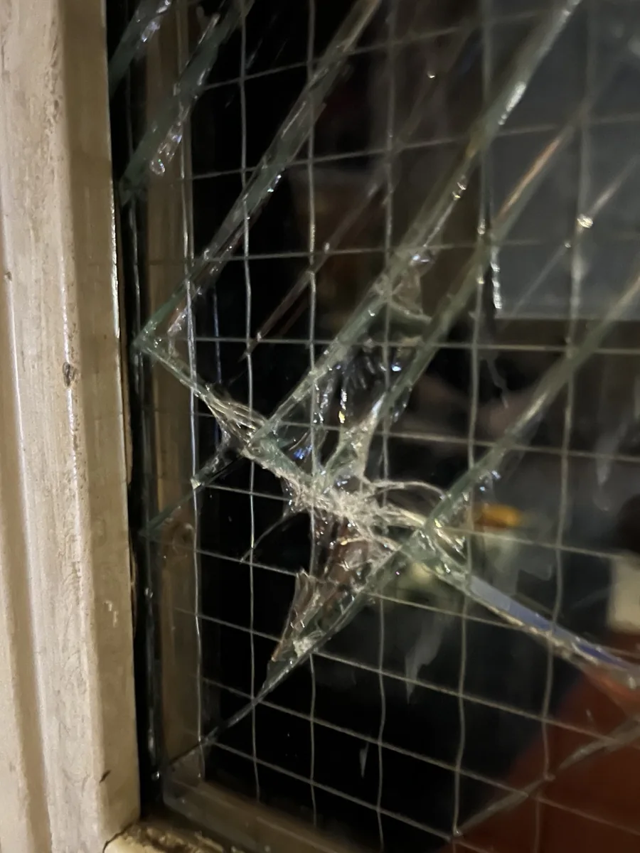 Broken GPW wired glass in a commercial opening before replacement