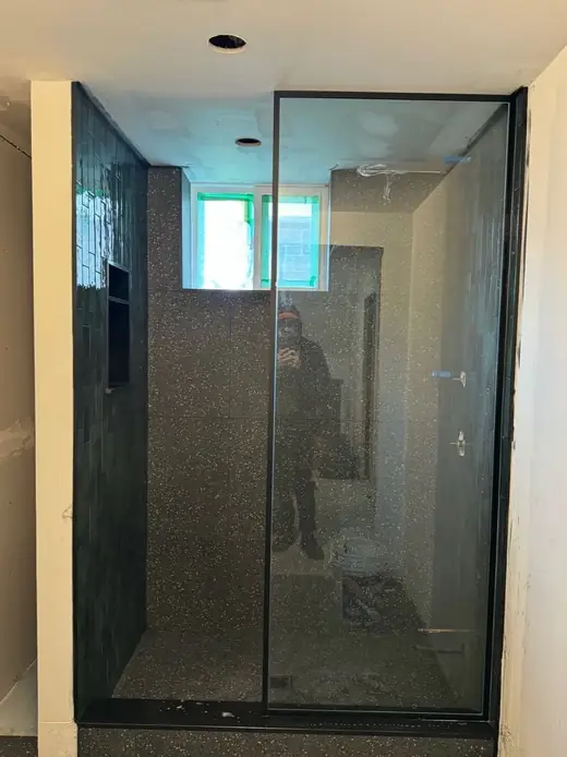 Walk-in frameless shower glass panel installed in Brampton with matte-black hardware