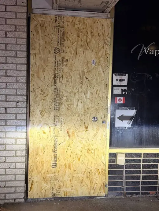 Damaged Mississauga shop door after break-in before board-up and replacement