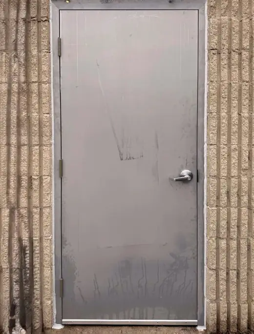 New commercial steel entry door with fresh perimeter caulking installed in Richmond Hill