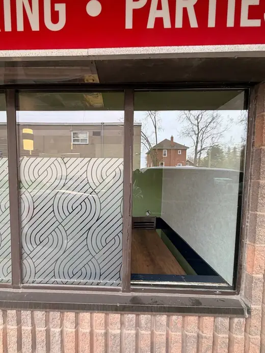 Burlington storefront window replaced with clear commercial glass after board-up