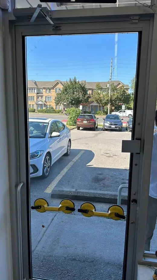 Full-height replacement glass being positioned in an aluminum commercial door in Vaughan