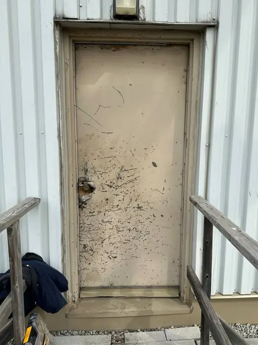 Failed exterior security door in Richmond Hill before commercial metal door replacement