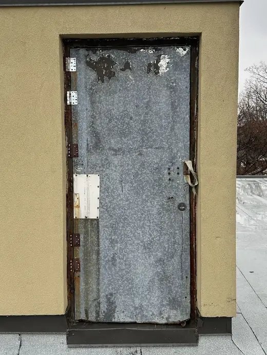 Weather-worn rooftop access door in Scarborough before replacement