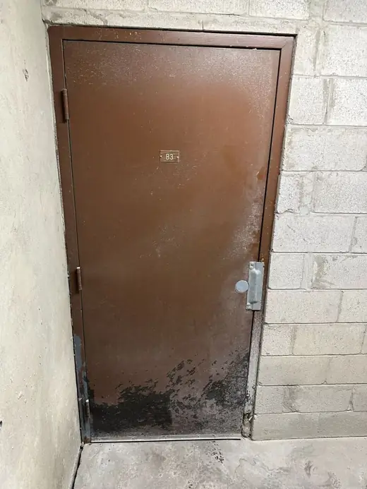 Old basement service door in Toronto before metal door replacement