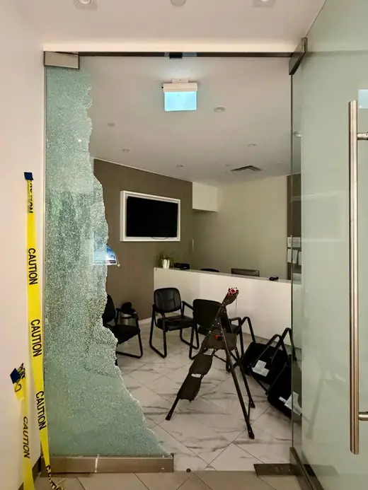 Shattered office glass partition in North York before emergency board-up