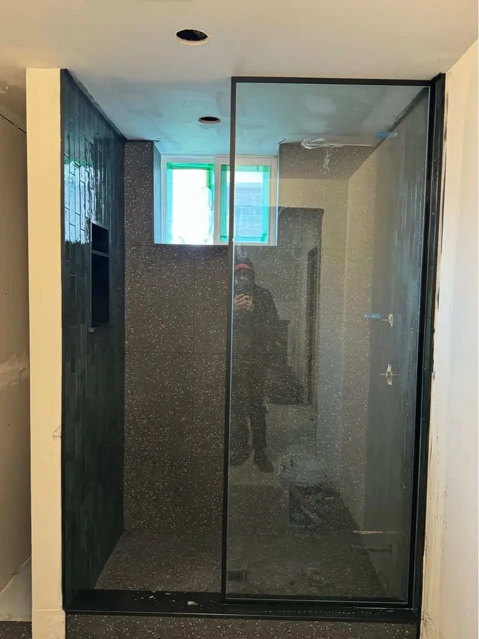 Walk-in frameless shower glass panel installed in Brampton with matte-black hardware