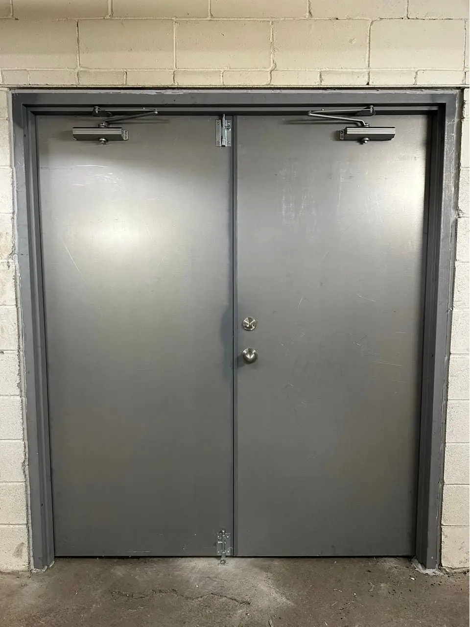 Clarington commercial steel door pair with one surface door closer on each leaf.
