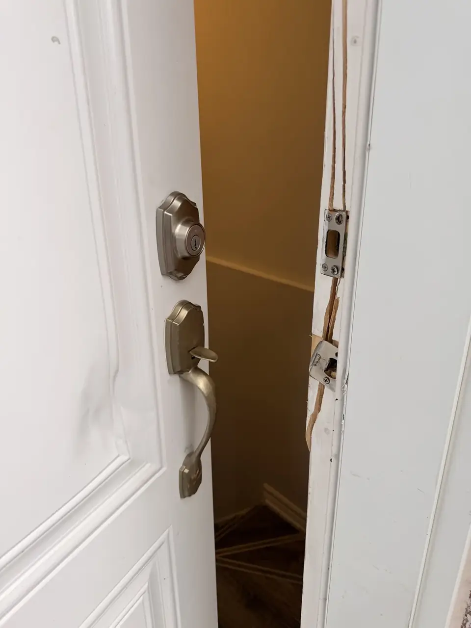 Exterior entry door in Aurora with break-in damage around the lock and latch edge before replacement