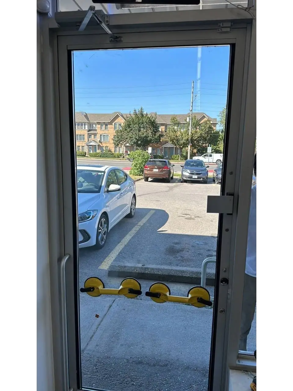 Large replacement glass panel positioned with suction equipment in the existing Vaughan aluminum entrance door.