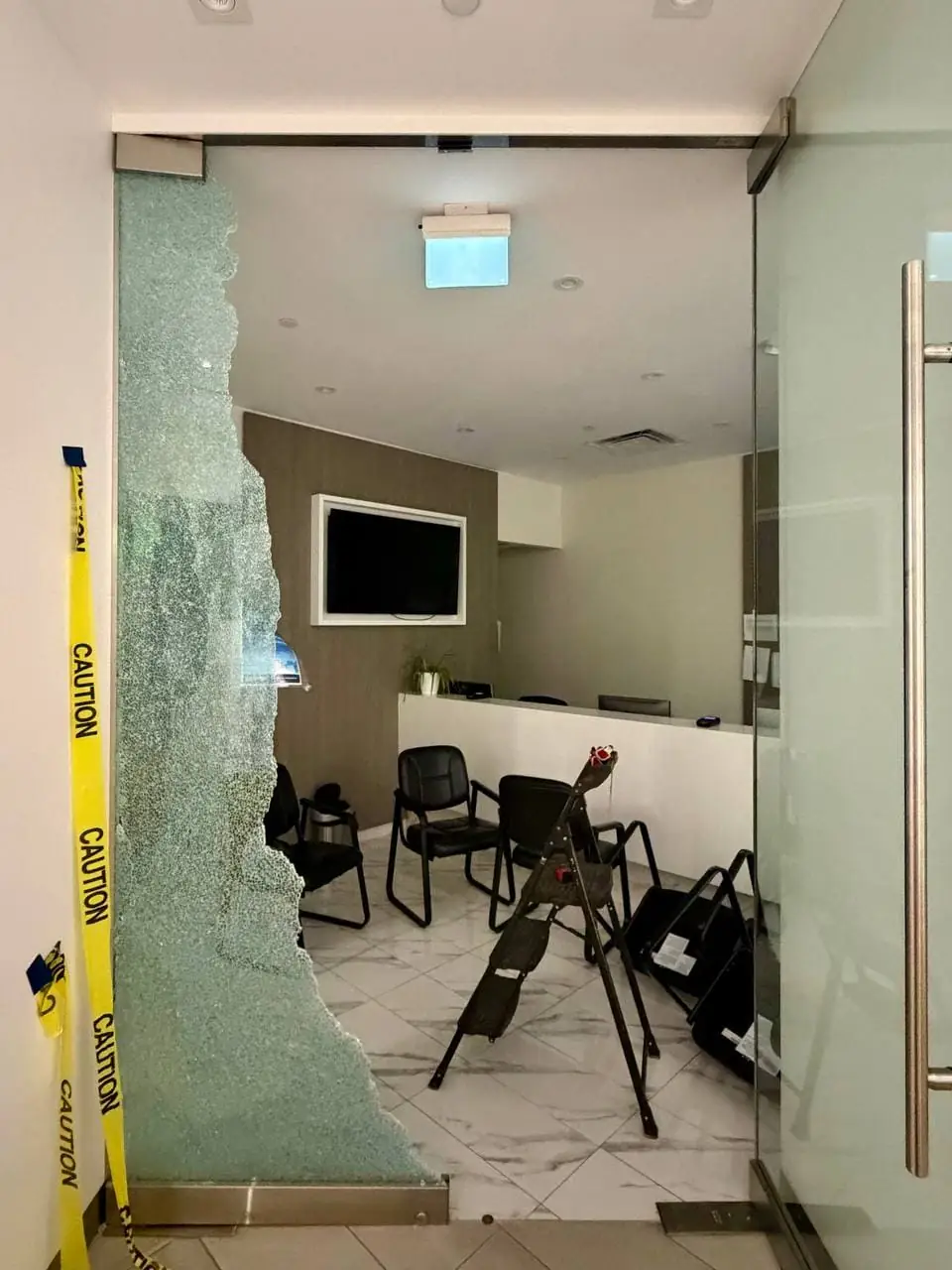 Shattered office glass partition in North York before emergency board-up