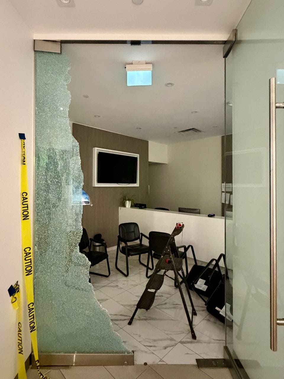 Shattered office glass partition in North York before emergency board-up