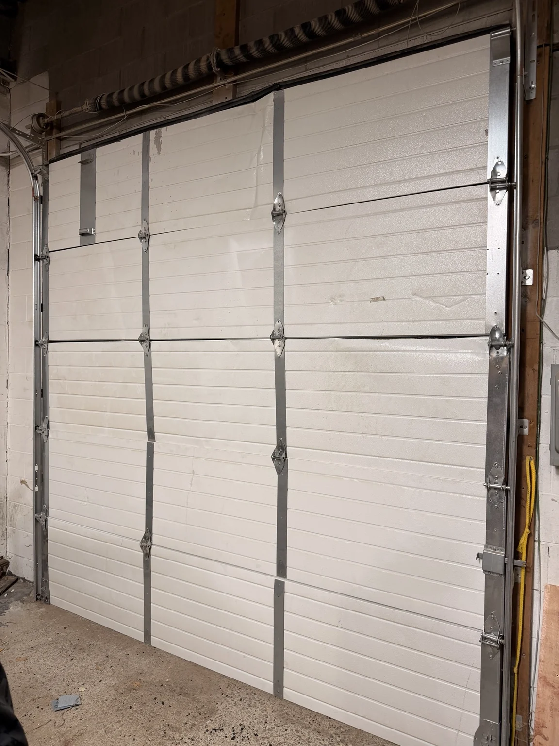 Interior view of stabilized commercial overhead garage door in Oshawa after emergency repair