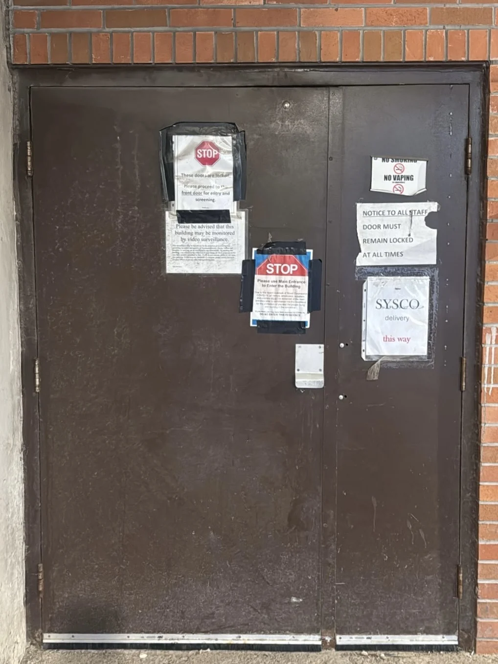Heavy steel commercial double door in Richmond Hill before the active leaf received better hinge support