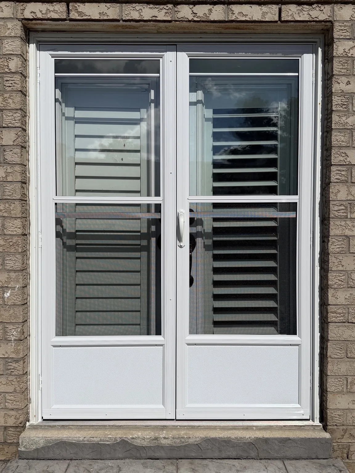 Pair of new white storm doors installed over a double entry in Vaughan