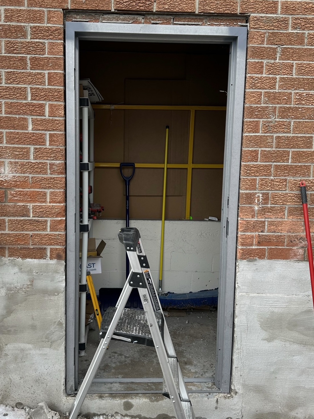 New hollow metal frame installed in exterior brick service-door opening