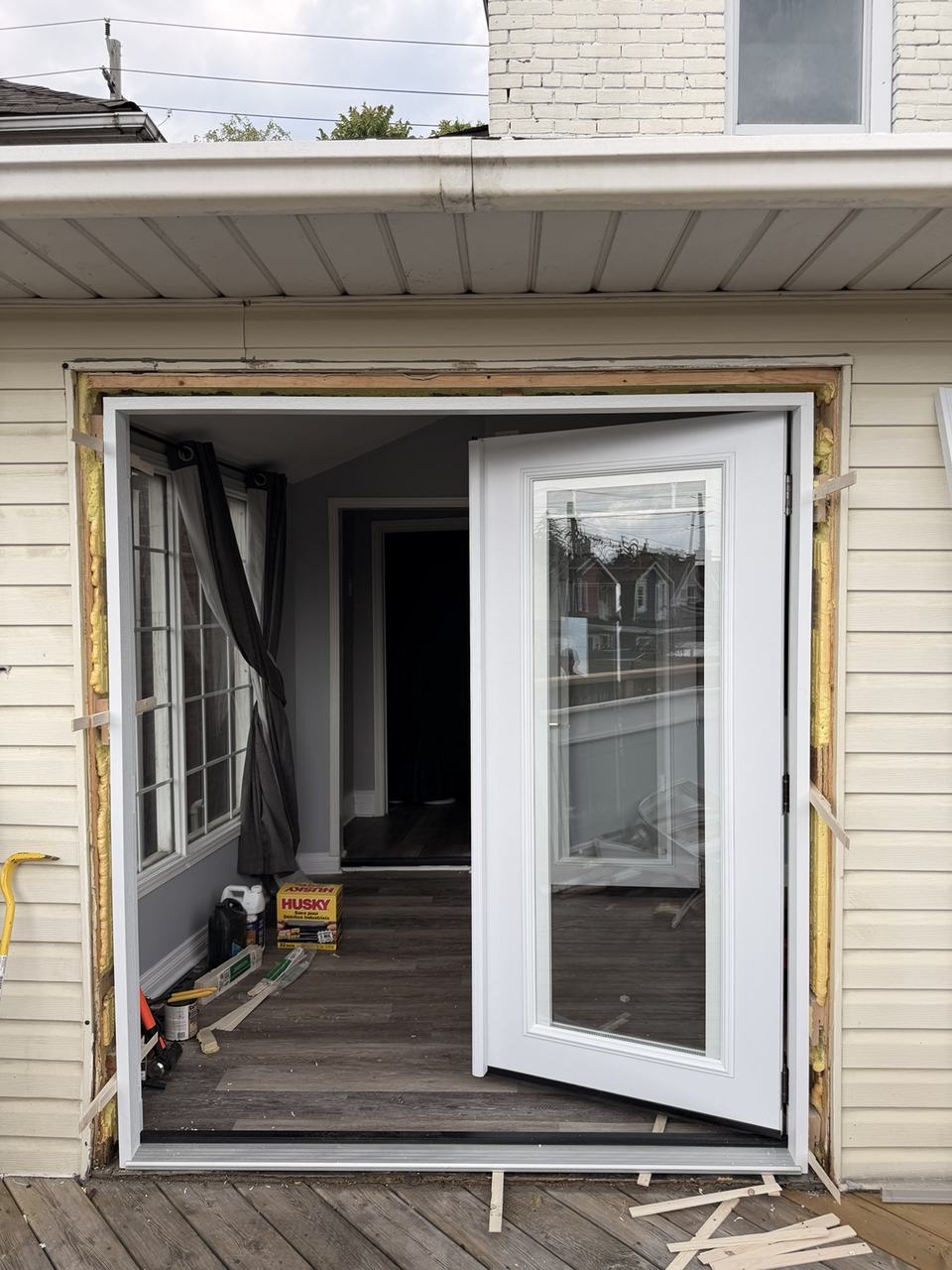 New French patio door frame installed and hinged panel checked for swing before final sealing