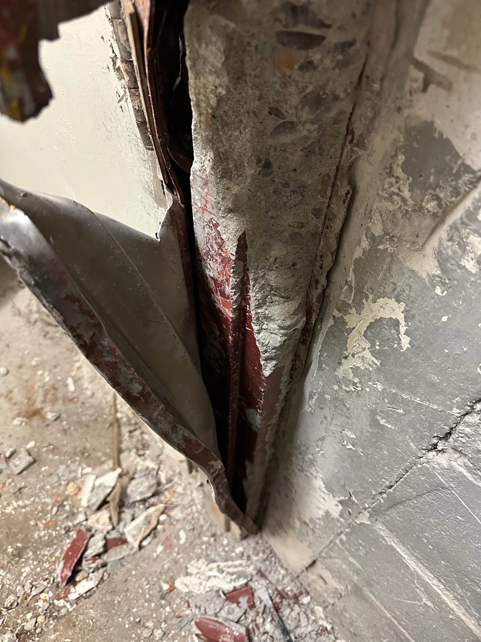 Old hollow metal door frame filled with grout and concrete inside a masonry opening