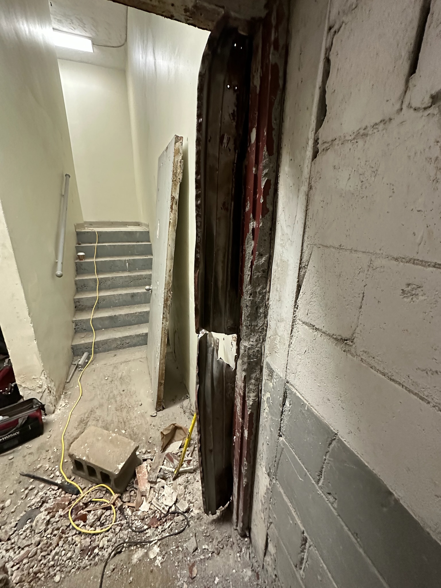 Grouted hollow metal frame cut out in sections during commercial door replacement