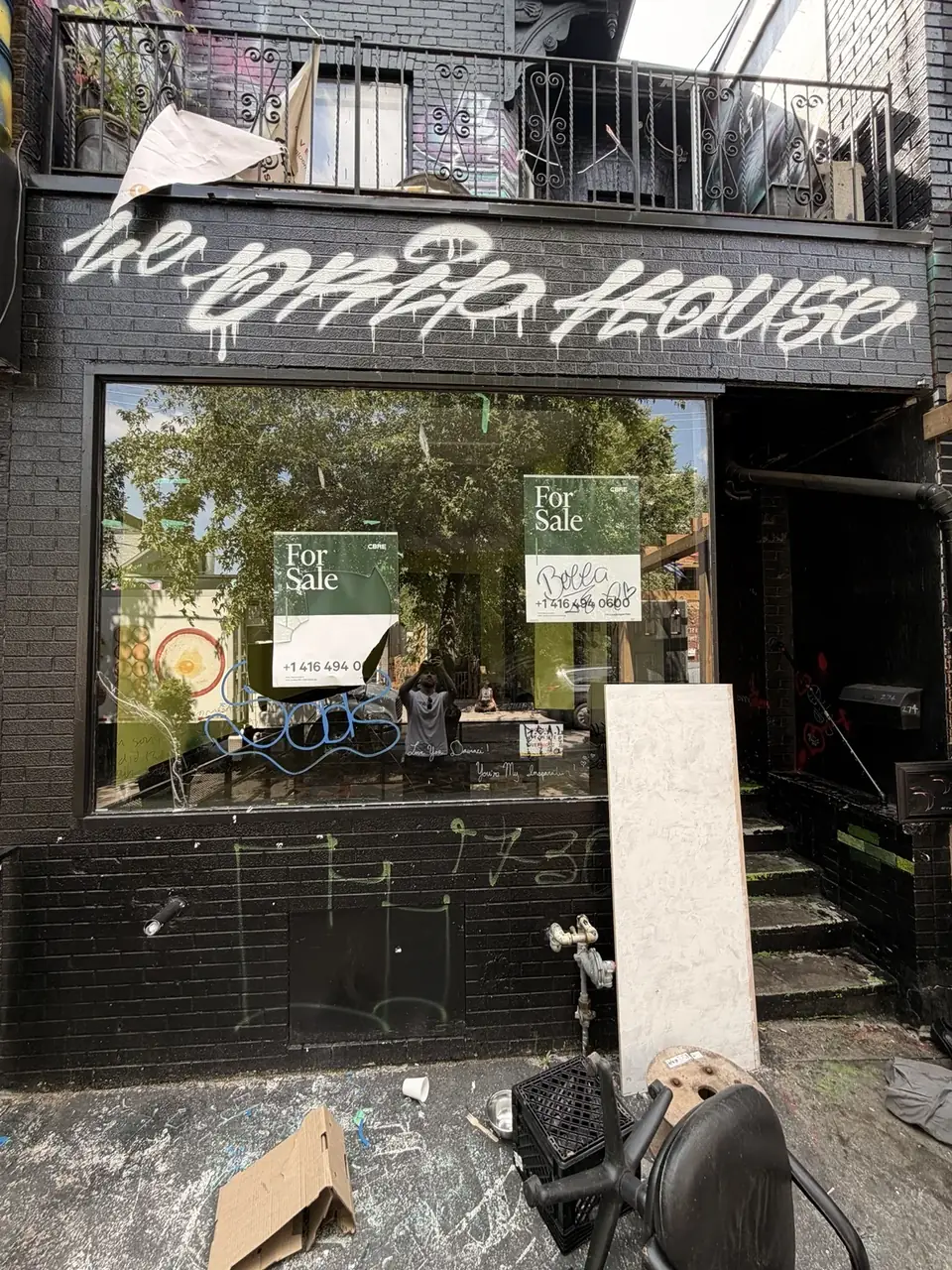 Broken storefront glass in Kensington Market, Toronto before emergency board-up