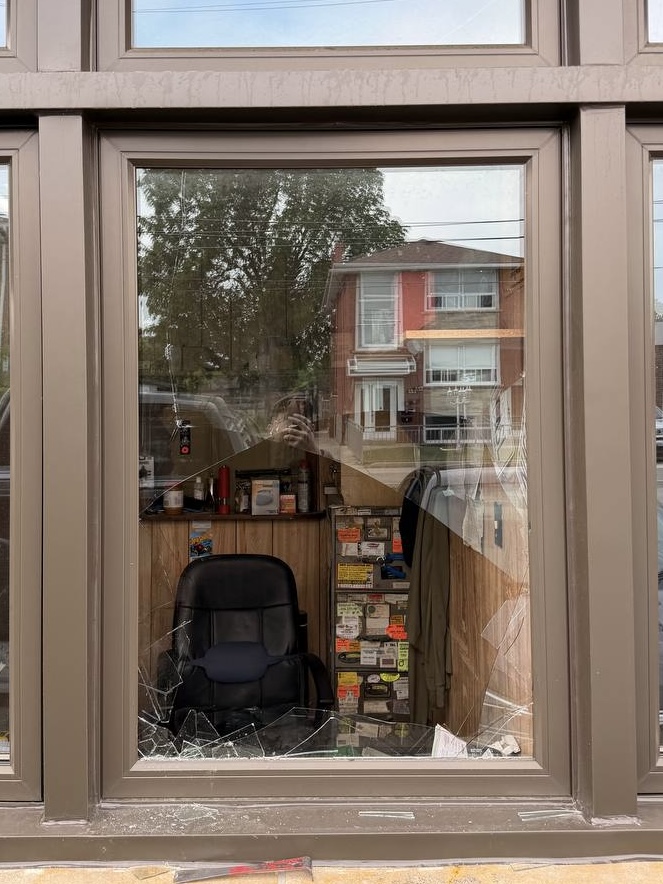 Broken commercial window at an auto repair shop in Mimico before emergency securing