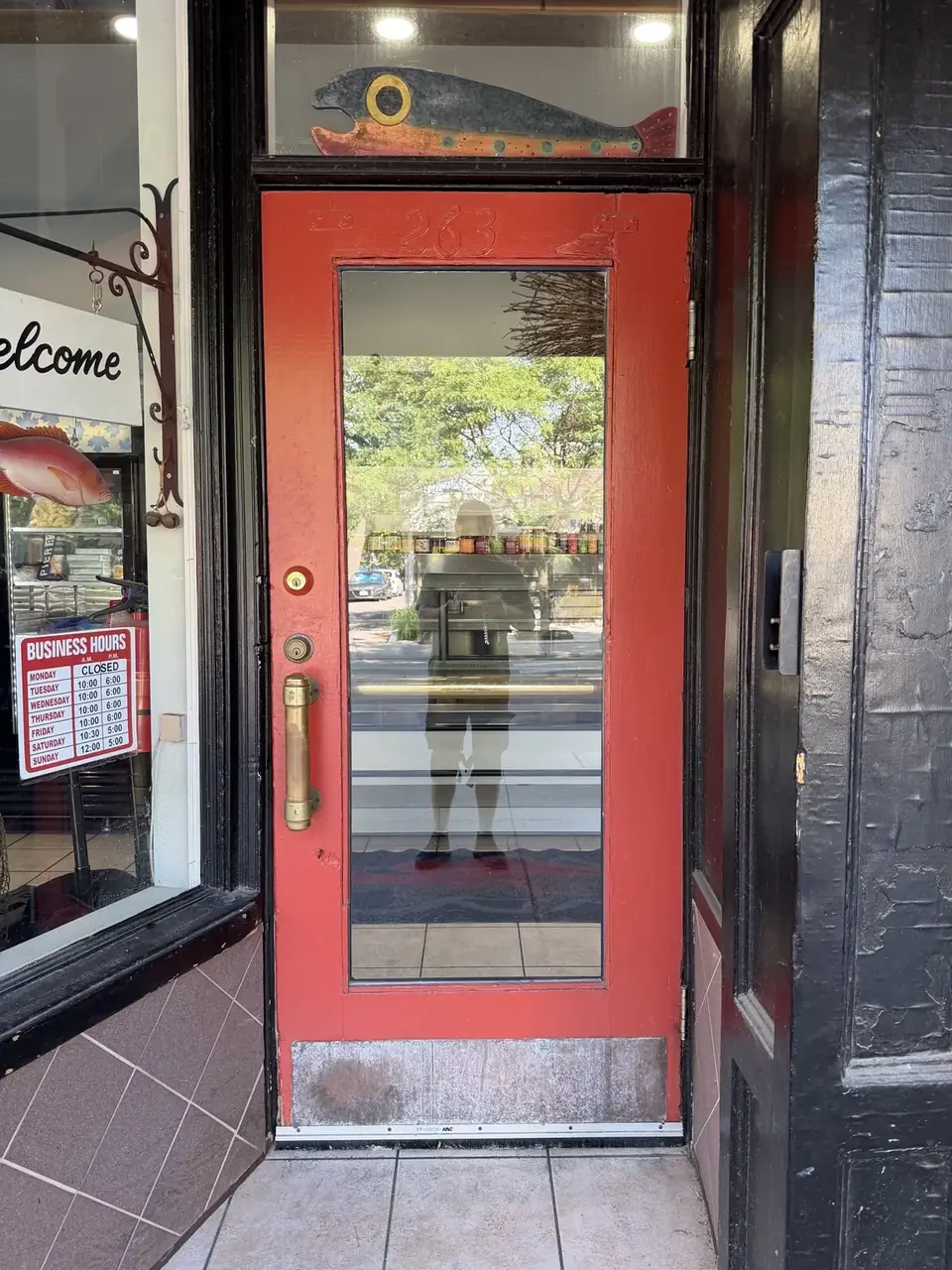 Existing red retail storefront entry door in Bloor West Village, Toronto before replacement