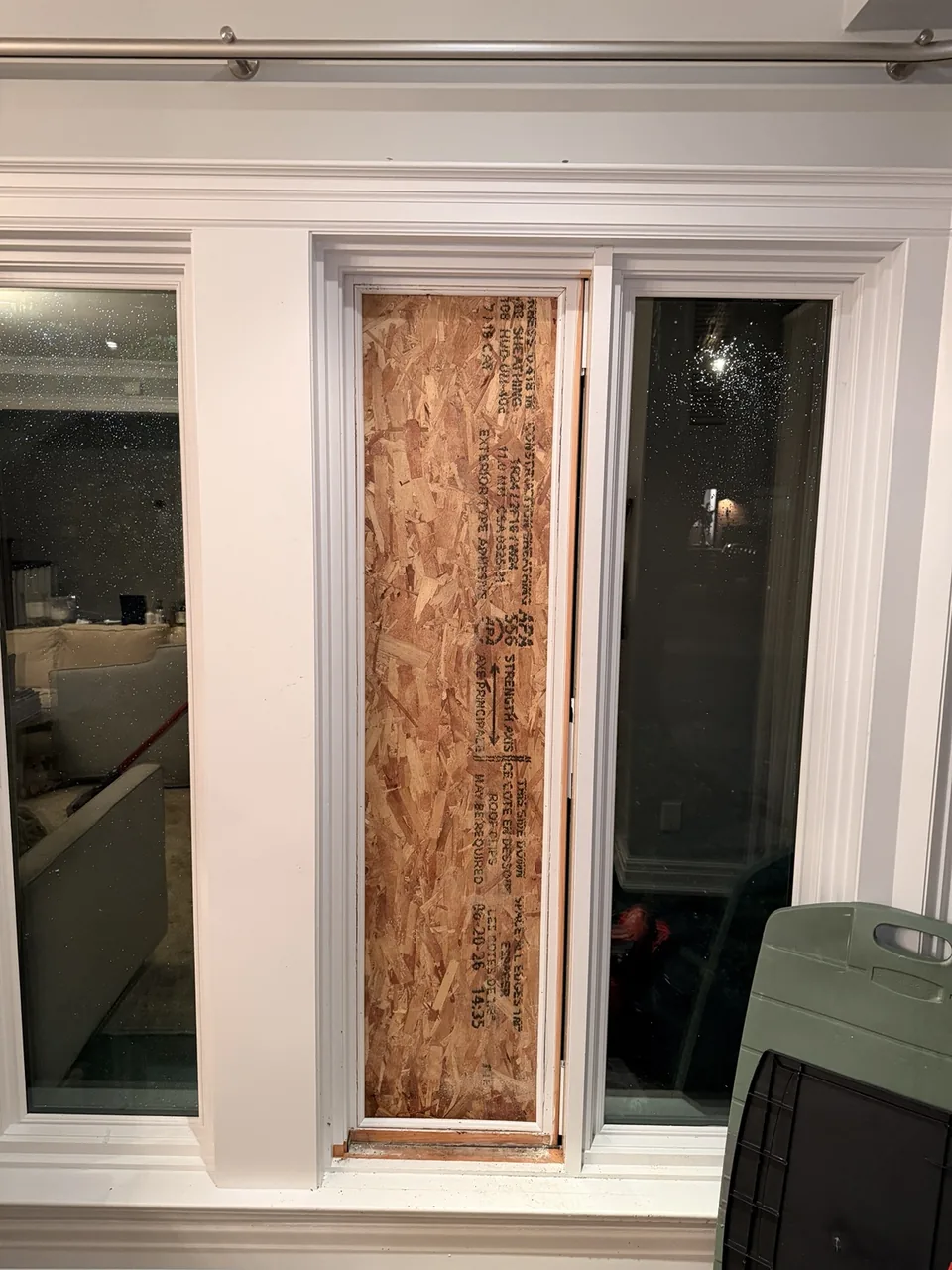 Interior view of the damaged window opening closed with temporary board-up